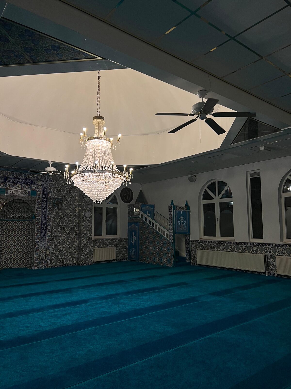De kristallen kroonluchter onder de koepel van de gebedsruimte, met de mihrab en de boogvensters
