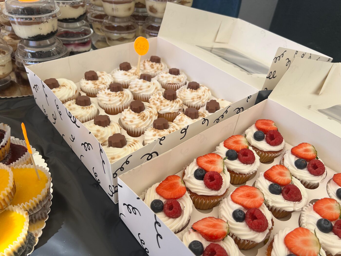Dozen met cupcakes met chocolade en met aardbeien en frambozen
