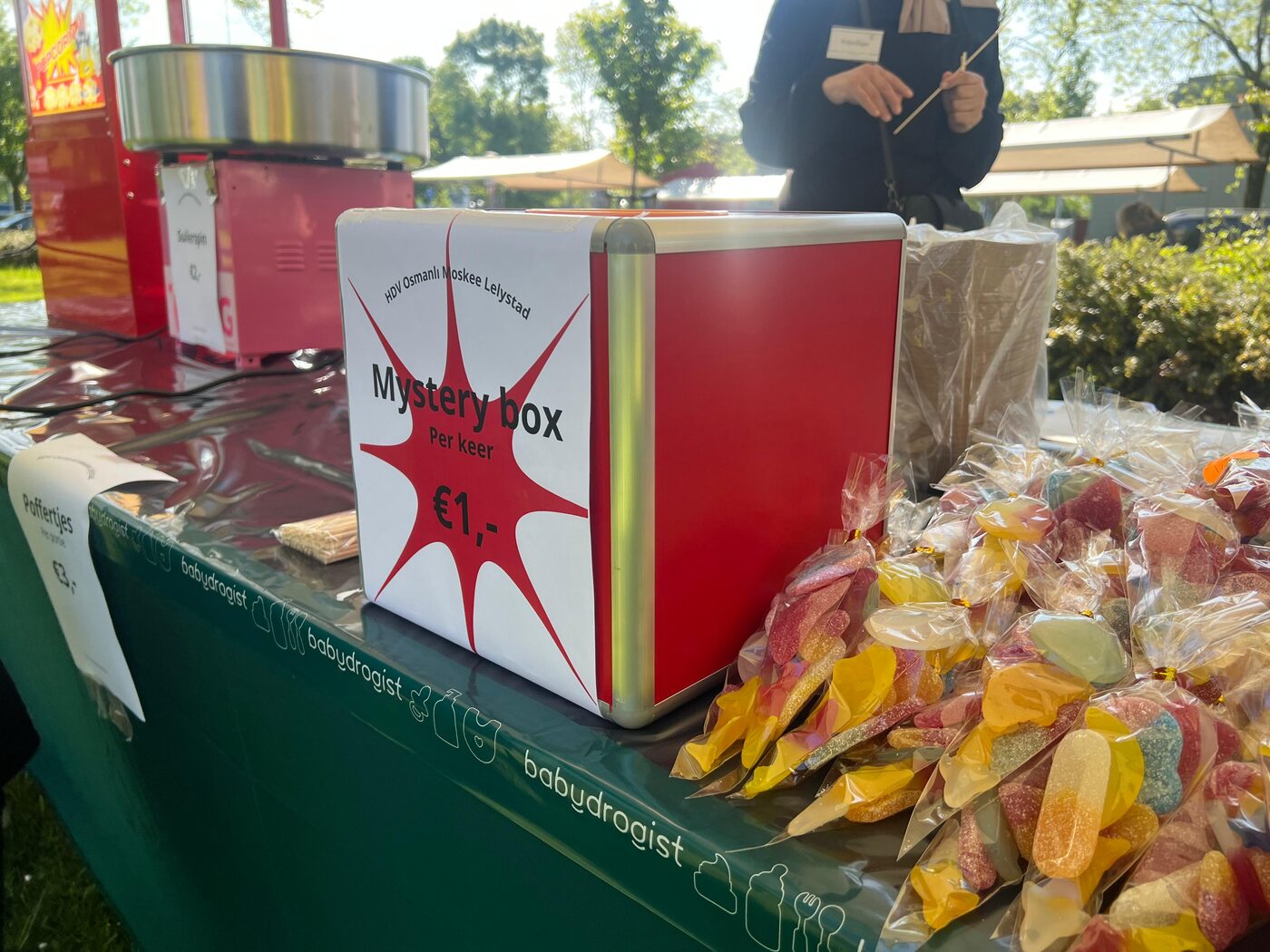 Een rode mystery box van één euro naast zakjes snoep en een suikerspinmachine