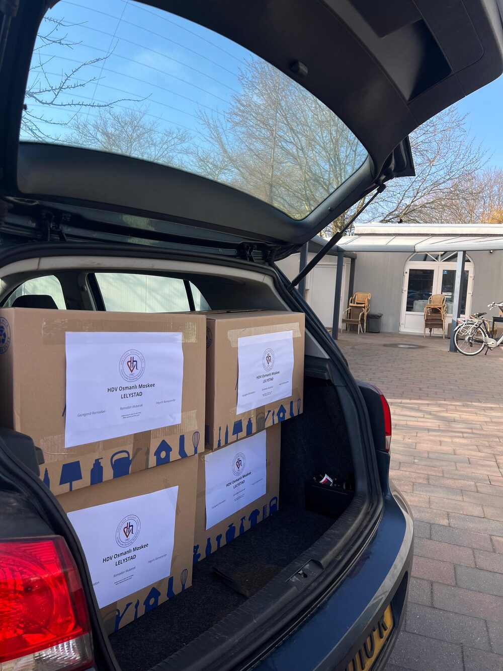 Ramadanpakketten in de kofferbak van een auto op het plein van de moskee